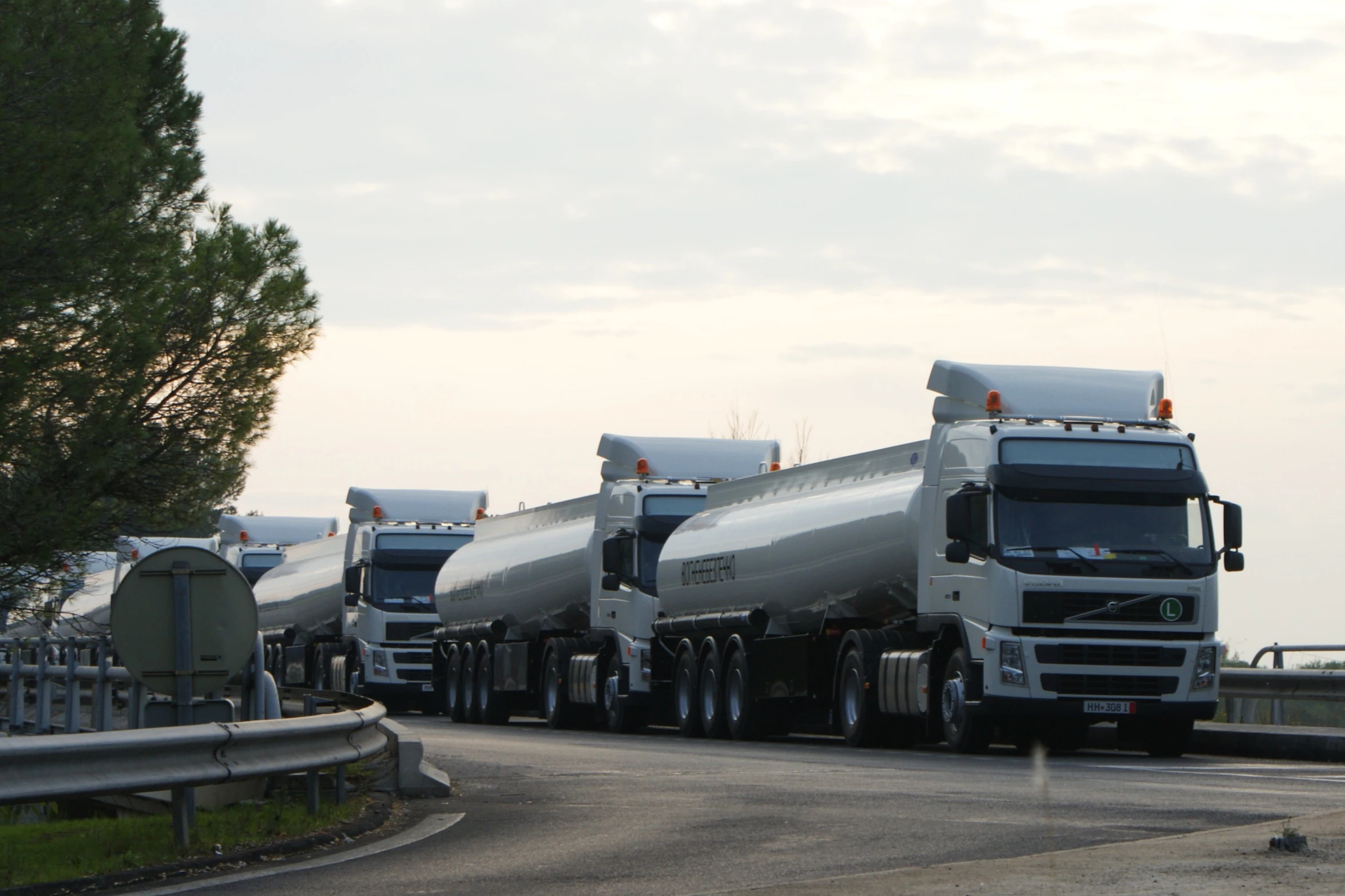 three tanker trucks parked in a line on the road