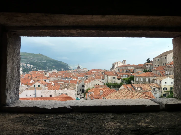 a very wide window with an old city seen in the background