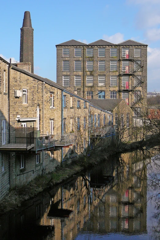 some buildings are reflecting the water by a bridge