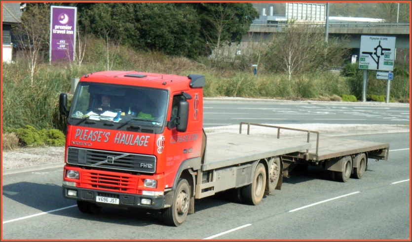 a large flat bed truck driving on the street