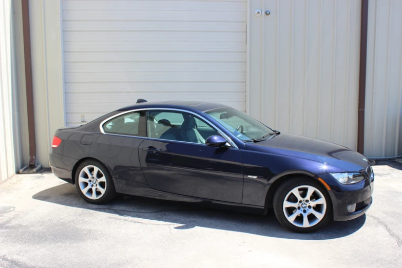 a silver car parked by a building with garage doors