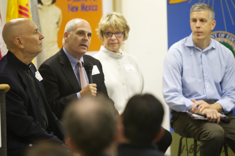 people sitting in chairs talking together at an event