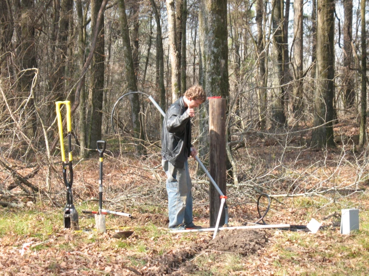 a man is standing in the woods holding soing