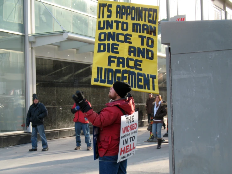 people standing on the street with signs reading it is appointed unto men once to face lucegentism