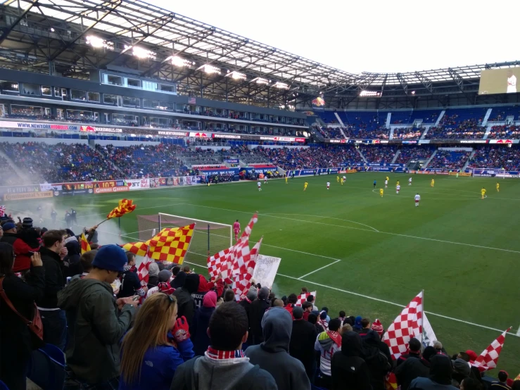 a large stadium with fans and red and white flags