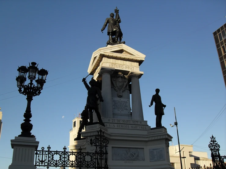 a statue stands near the clock and street light