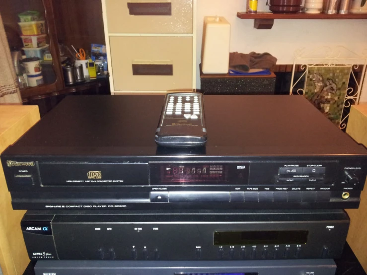 a stack of stereo tapes with an old tv on top