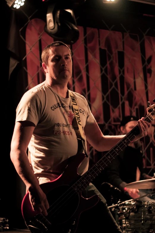 a man with an electric bass guitar on stage