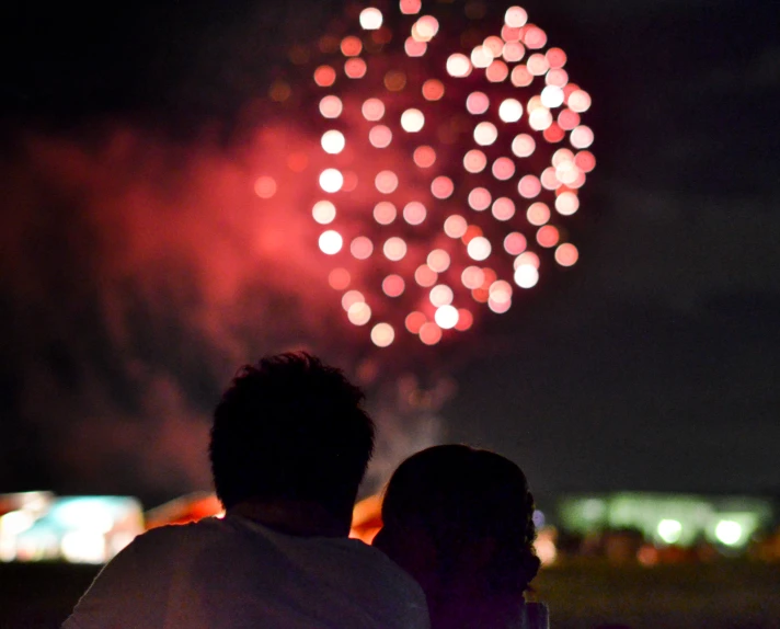 people are sitting in front of a fireworks display