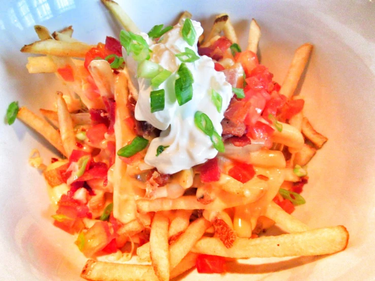 a pile of fries sitting on top of a white plate