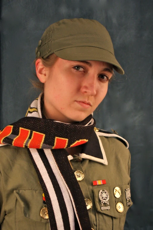 a young woman in army clothes wearing a hat and a tie