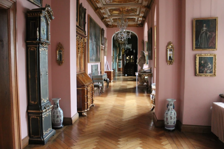 the ornate hallway of a palace with paintings and a piano