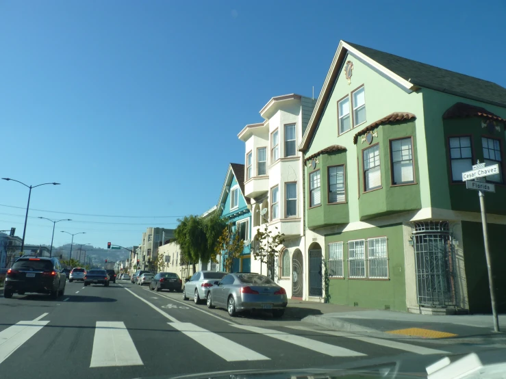 cars parked in a line along a street that has houses on it