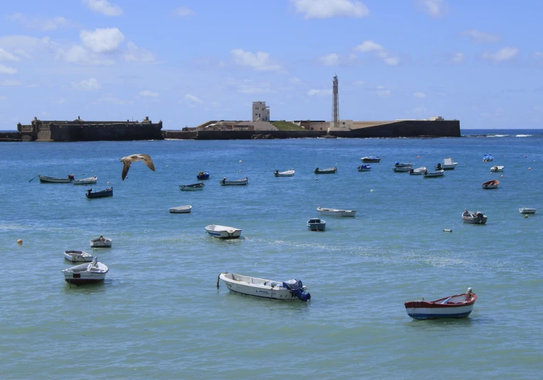 small boats anchored in the blue sea near an island