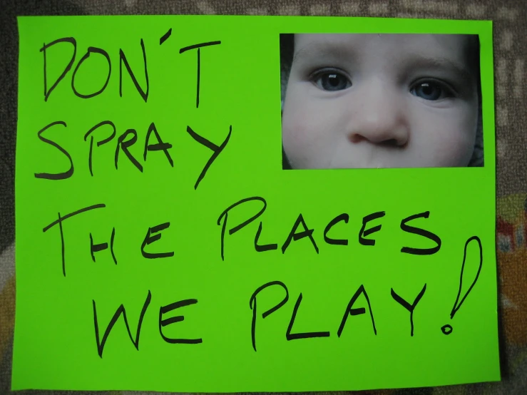 a child looking at a poster saying don't spray the peace we play