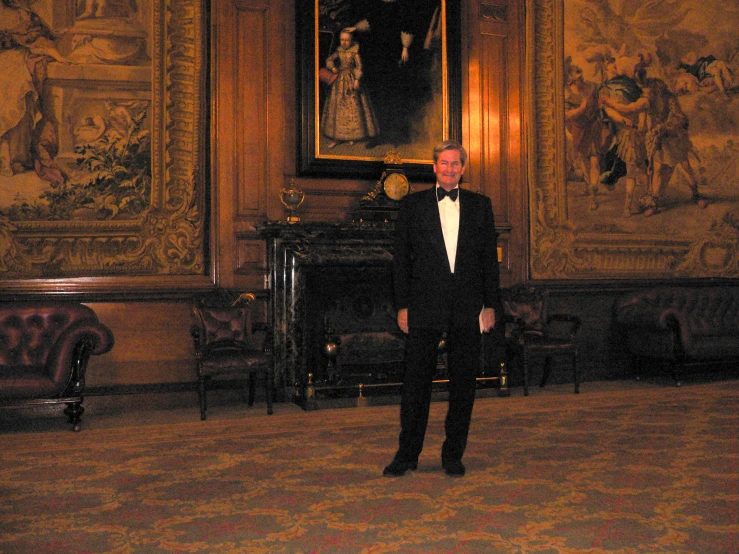 a man wearing a black tuxedo in an ornate room