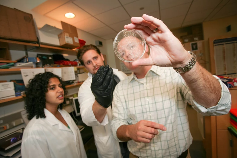 two people in a lab holding up a beak