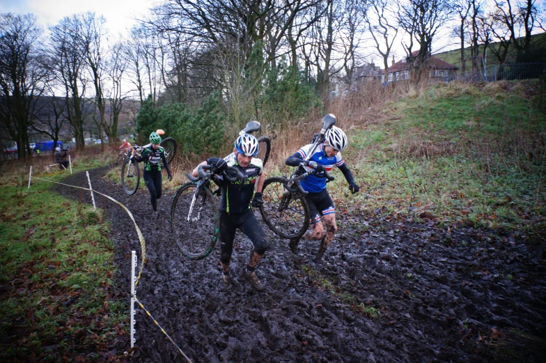 a group of people on muddy trail with trees