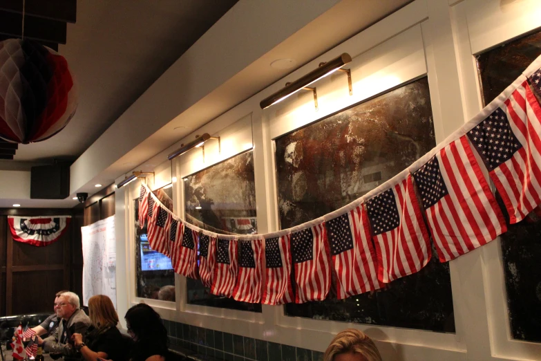 several people sitting at tables with american flags