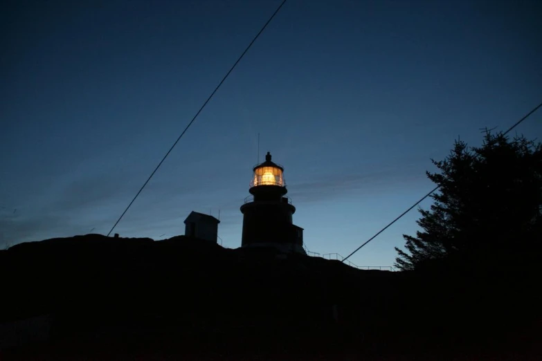 a light tower at night sitting on top of a hill