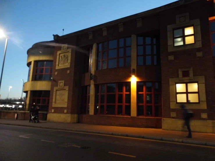 a motorcyclist is passing by an old building at night