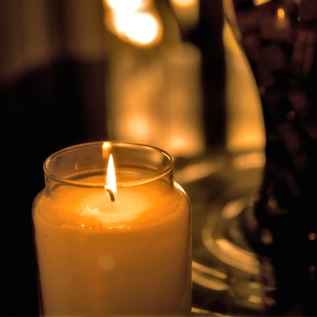 lit candles sit next to each other on a table