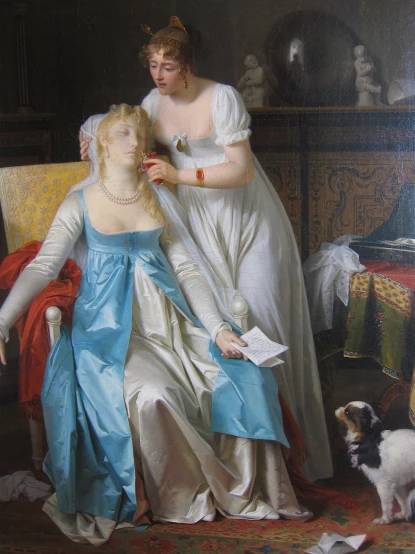a lady in a blue dress is shaving another lady's hair