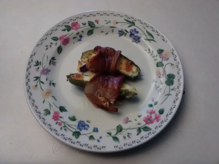 the plate has bacon and an eggplant on it