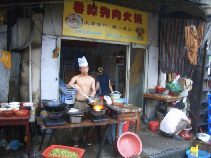 three people are cooking on the street