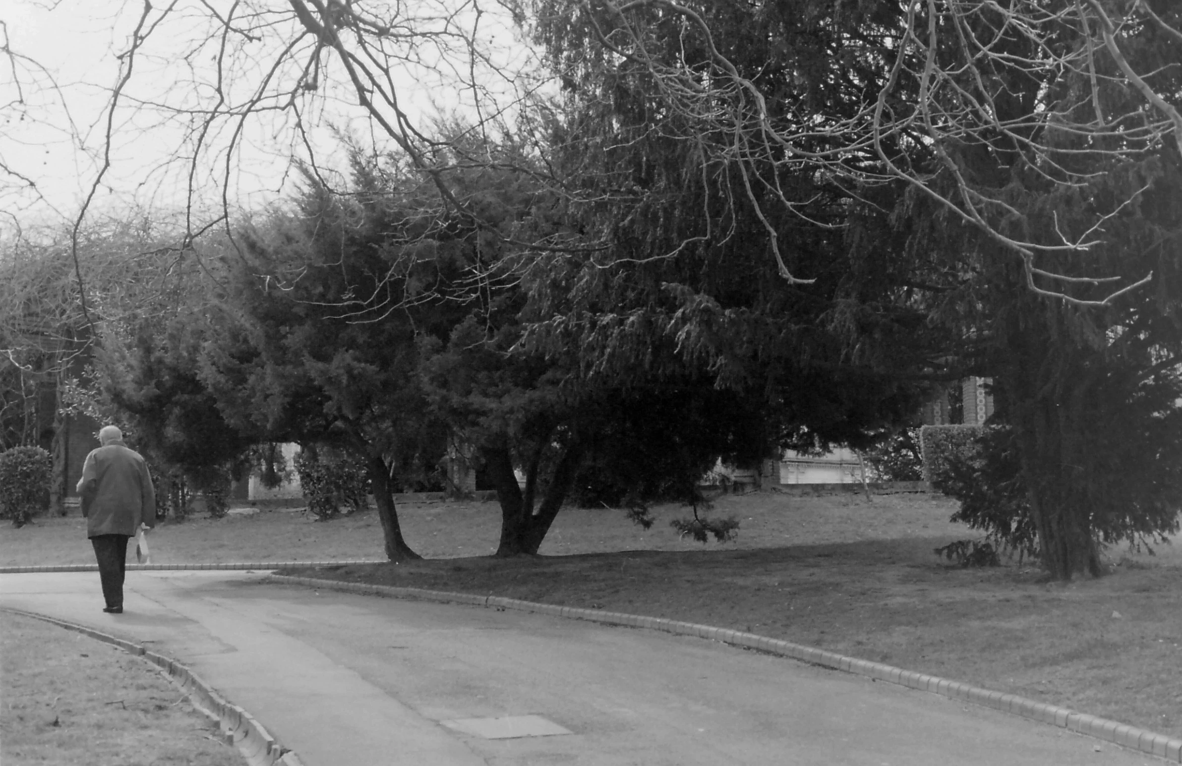 a black and white image of a man walking down the street