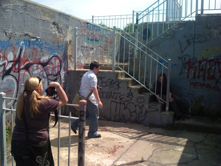 two people are standing by some stairs with graffiti on them