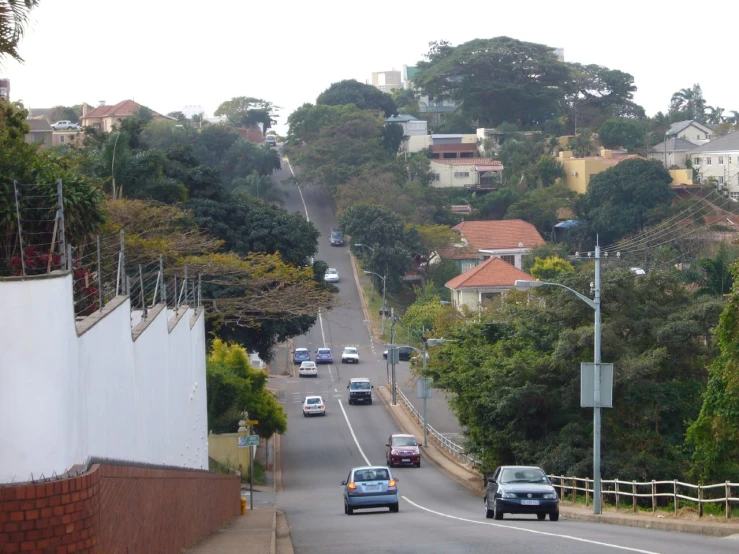 cars are traveling down the road on a steep hill