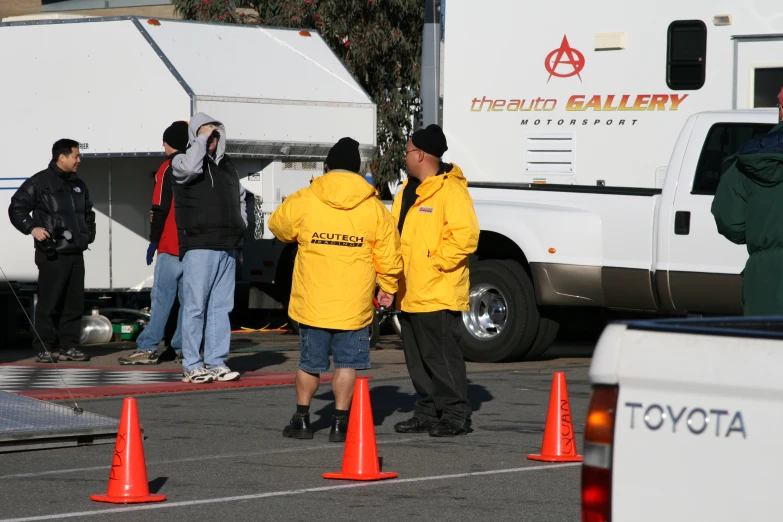 the people in yellow are standing near the delivery truck