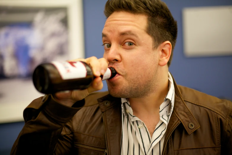 a man with a drink in his mouth drinking it