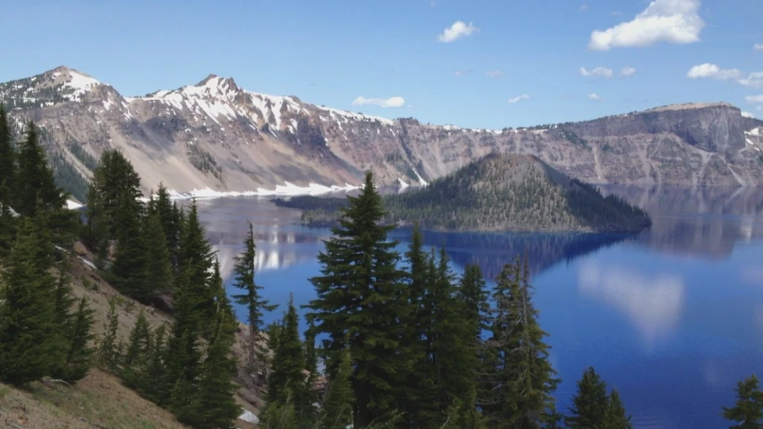 mountains, water and pine trees surrounding a lake