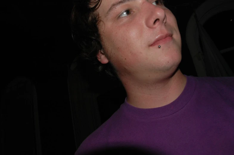 a close up image of a man in a purple shirt