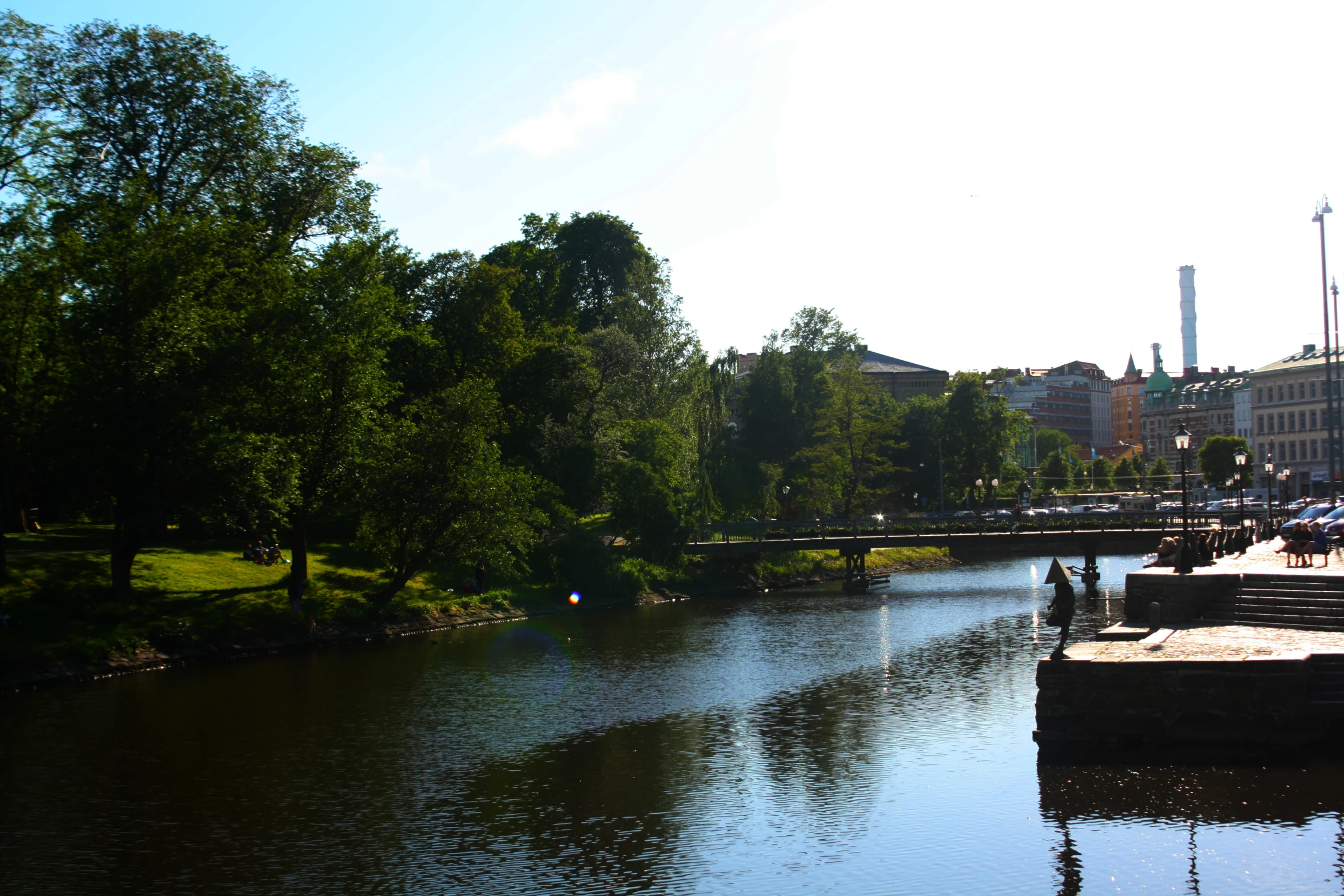 the river runs between some buildings and park