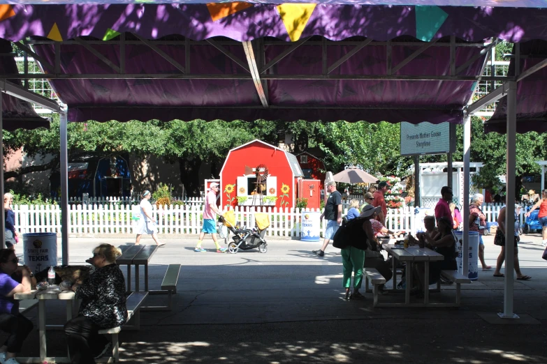 many people are sitting under the covered outdoor seating area