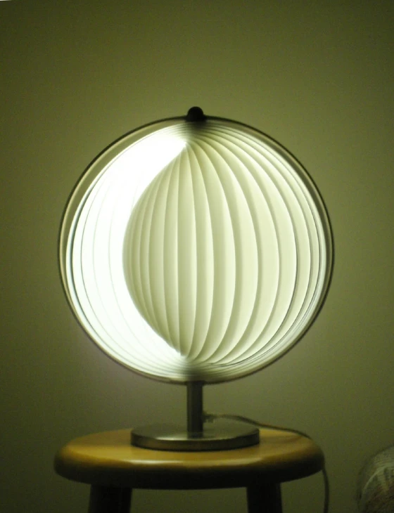 a round table lamp sits on top of a wooden chair