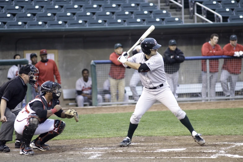 the catcher and umpire look on as a player prepares to catch a baseball