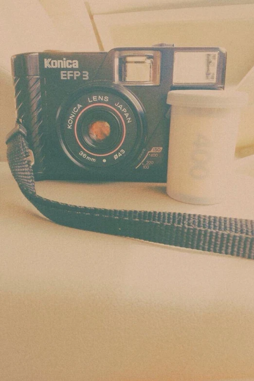 an image of a camera and coffee sitting on the bed