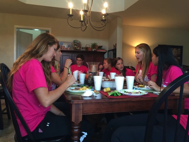 a group of women at a table eating together