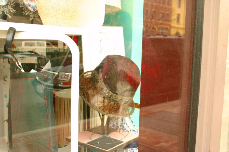 a hat is sitting on a stand behind a glass door