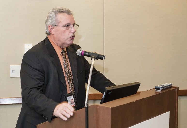 man in business suit making a point to a speaker