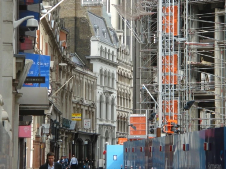 a city street with tall buildings and scaffolding