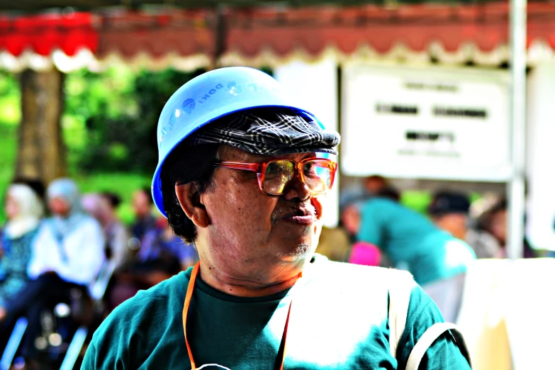 man wearing a blue hard hat and holding a camera