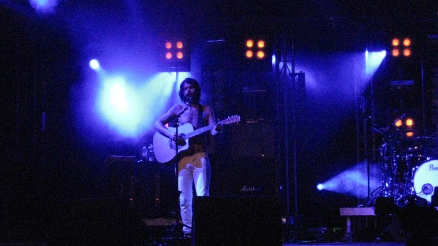 a person that is on stage with a guitar