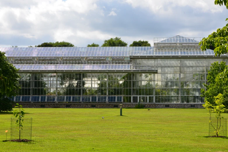 a big glass building that is on the side of a field