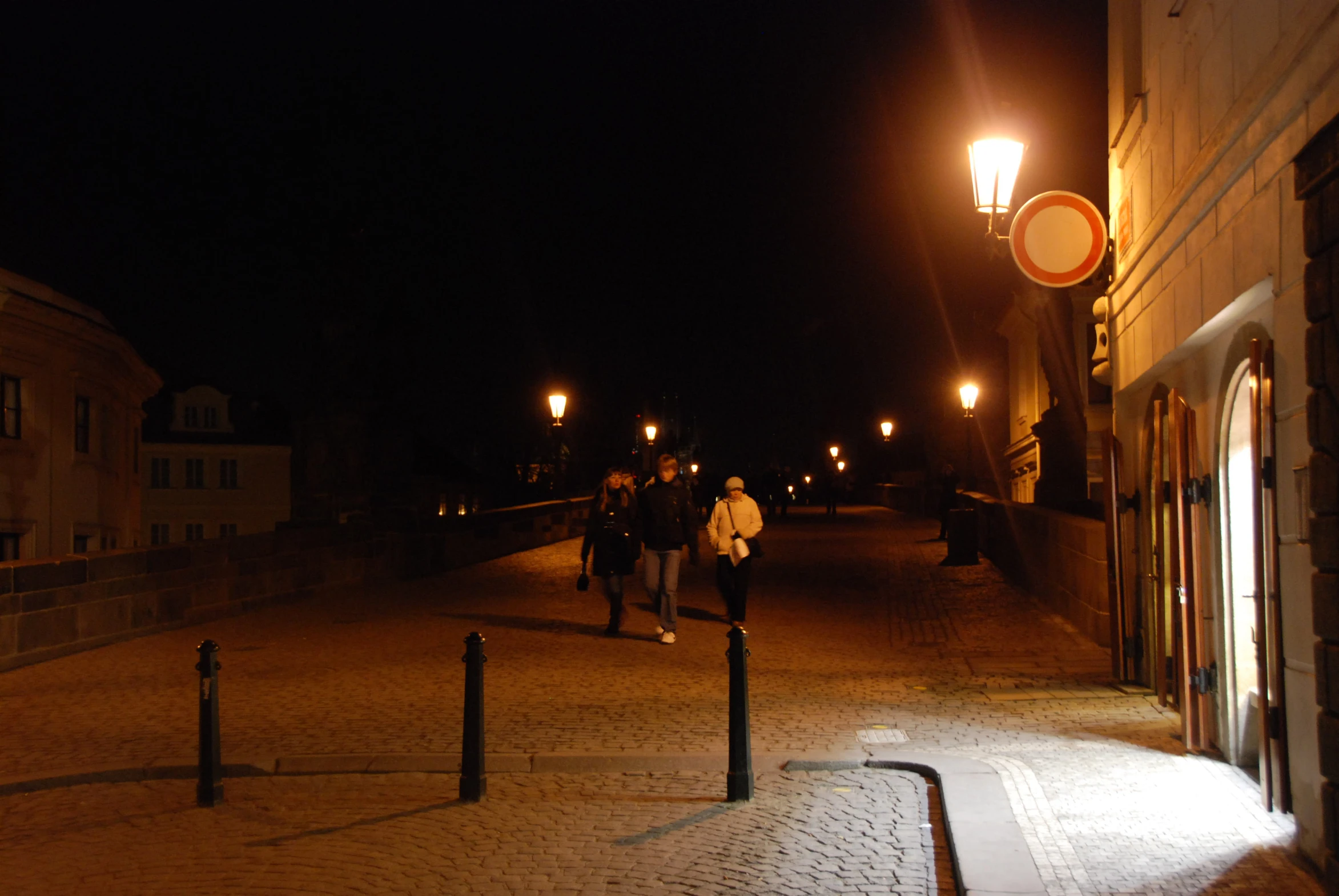 a woman walking down a street next to a parking meter