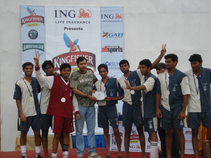 a group of young men holding up a trophy